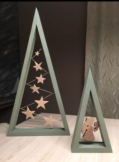 two small wooden christmas trees with stars on them