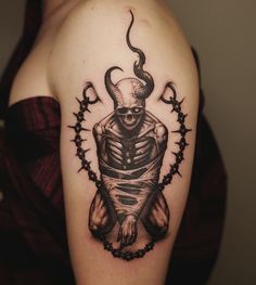 a man's arm with a tattoo on it and an image of a demon