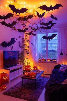 a living room decorated for halloween with bats hanging from the ceiling