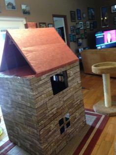 a house made out of bricks sitting on top of a rug in a living room