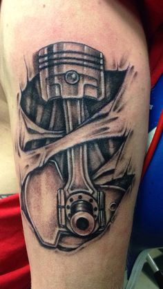 a man's arm with a tattoo on it that has an image of a car engine