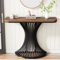 a table with a mirror and some books on it next to a plant in a vase