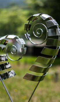 a close up of a metal sculpture in the grass