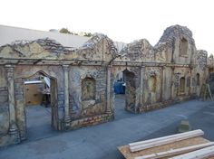 an old stone building is being built into the side of a building that looks like it's made out of wood