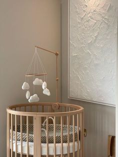 a baby crib in a room with white walls and wood trim around the crib