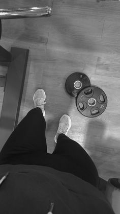 a person with their feet up in the air on a gym floor next to a weight scale