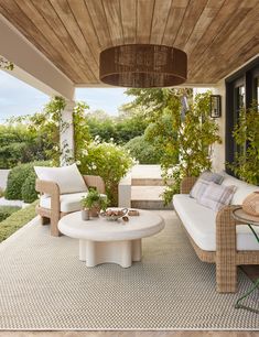 an outdoor living area with wicker furniture and potted plants