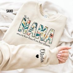 "Custom Nana Sweatshirt, I Wear My Heart On My Sleeve, Gift for Mom, Nana Sweatshirt with Grandkids Name, Personalized Sweater, Grandma Gift Thank you for shopping with us❤️ Size - Our products are unisex fit - You can check our size and color charts on our listing photos. How To Order - Select a size - Select a t-shirt color - If available, indicate the design (text) color in the personalization box - Click add to cart. You can go back to add more shirts. - Click \"Proceed to check out\". Care Instruction -Machine wash in cold water -Do not use bleach -Tumble dry low -Inside out, wash with delicate cycle -Do not iron directly over design Production and Shipping - Processing is 1-3 days * Shipping Time is depending on the shipping option that you choose during to checkout process - Please Sweatshirts For Grandma, Quotes Grandma, Nana Sweater, Gift Idea For Grandma, Nana Sweatshirt, Monogram Sweater, Heart On My Sleeve, Grandma Quotes, Personalized Sweater