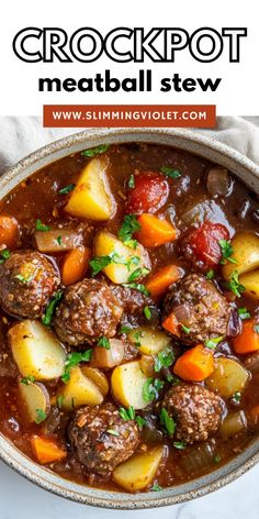 a bowl filled with meatballs and potatoes on top of a white tablecloth next to a