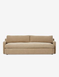 a beige couch sitting on top of a white wall