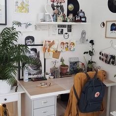 a white desk topped with a laptop computer next to a potted plant