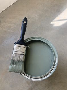 a paint can with a brush in it