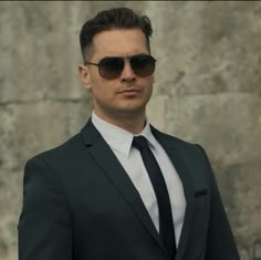 a man in a suit and tie wearing sunglasses