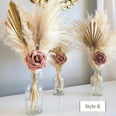 three vases with flowers and feathers in them