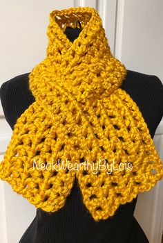 a yellow crocheted scarf on top of a mannequin