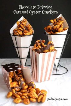 chocolate drizzled caramel oyster crackers in striped paper bags on a white table