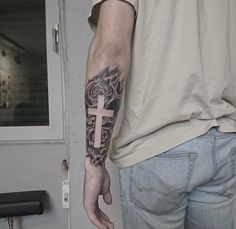 a man with a cross tattoo on his arm