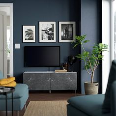 a living room with blue walls and pictures on the wall, including a large television