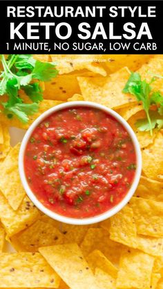 a bowl of salsa with tortilla chips and cilantro on the side