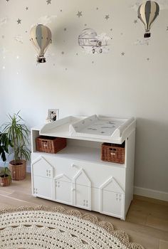 a baby's room with hot air balloons on the wall