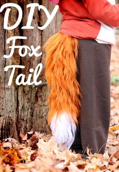 a woman standing next to a tree with an orange tail