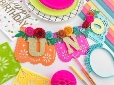 a table topped with plates and paper flowers