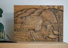 a wood carving of a house and ducks