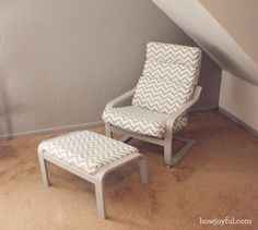 a chair and foot stool in a room under a slanted ceiling with an attic