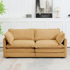 a tan couch sitting in front of a white wall