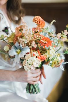 a woman holding a bouquet of flowers in her hands