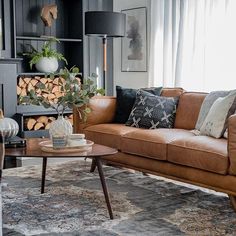 a living room filled with furniture and a fire place in front of a large window