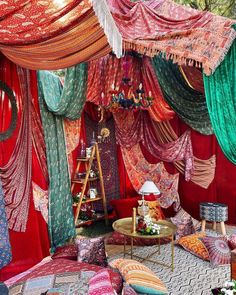 a bed covered in lots of different colored fabrics