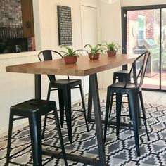 a dining room table with four chairs and a potted plant on the top shelf