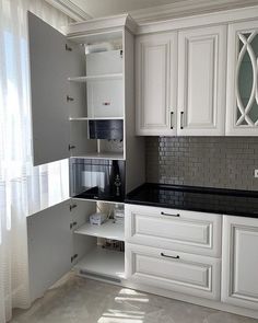 a kitchen with white cabinets and black counter tops