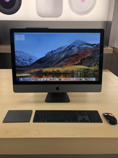 a desktop computer sitting on top of a wooden desk next to a mouse and keyboard