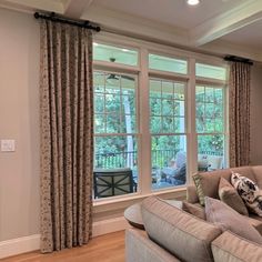 a living room with two couches and large windows in the wall to the outside