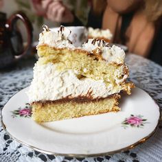 a piece of cake sitting on top of a white plate next to a tea cup