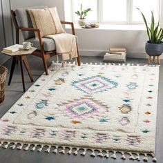 a living room area with a rug, chair and potted plant