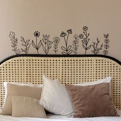 a bed topped with lots of pillows next to a wall mounted above it's headboard