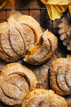 some cookies are on a cooling rack with autumn leaves and pumpkins in the background