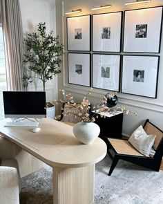 a white table and chairs in a room with pictures on the wall behind it,