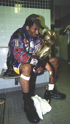 a man sitting on a bench holding a trophy