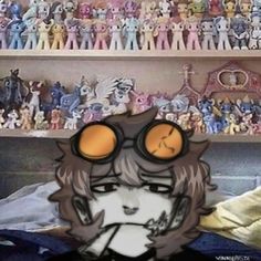 an anime character with large glasses on his face in front of a shelf full of stuffed animals