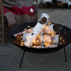 a black bowl filled with white firewood and christmas lights