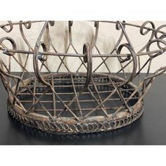 an old metal basket sitting on top of a table