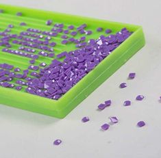 a green tray filled with purple confetti on top of a white countertop