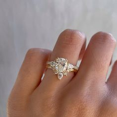 a woman's hand with a diamond ring on top of her left hand,