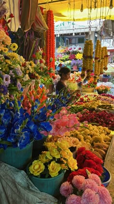 an outdoor market with many different types of flowers