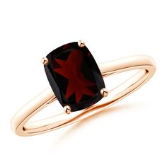 a gold ring with a red stone in the center and two black diamonds on each side