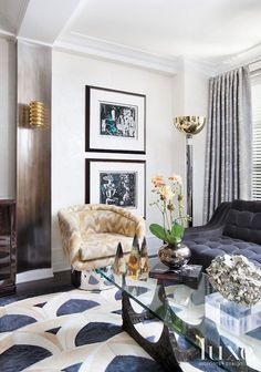 a living room filled with furniture and pictures on the wall next to a table in front of a window